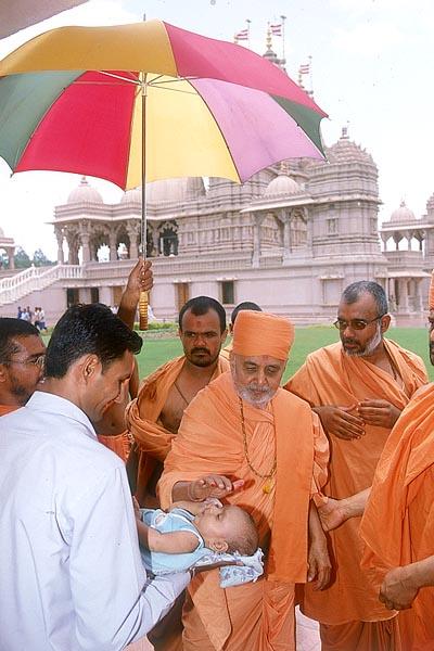 Swamishri blesses a little child 