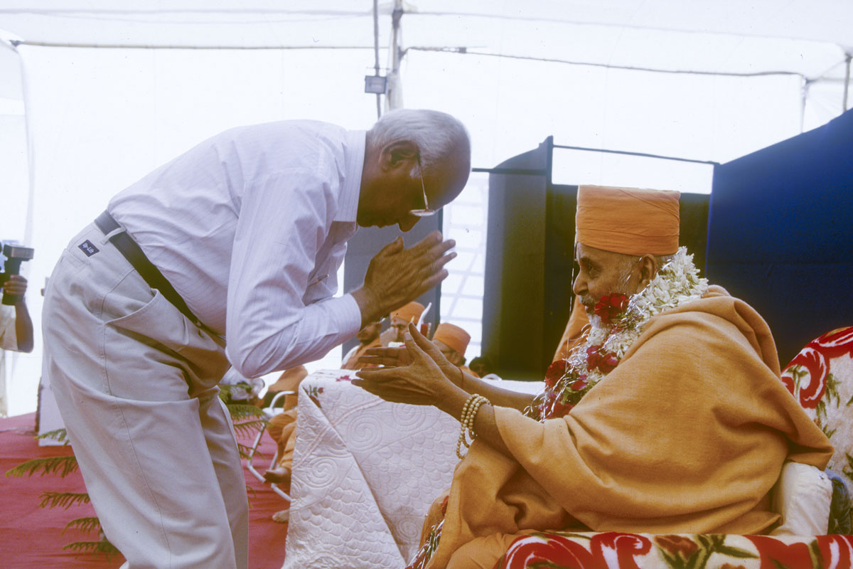 A dignitary welcome Swamishri with a garland