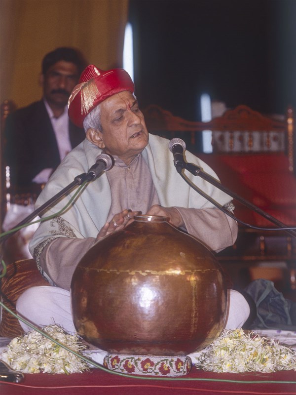 A devotee sings a kirtan in the assembly