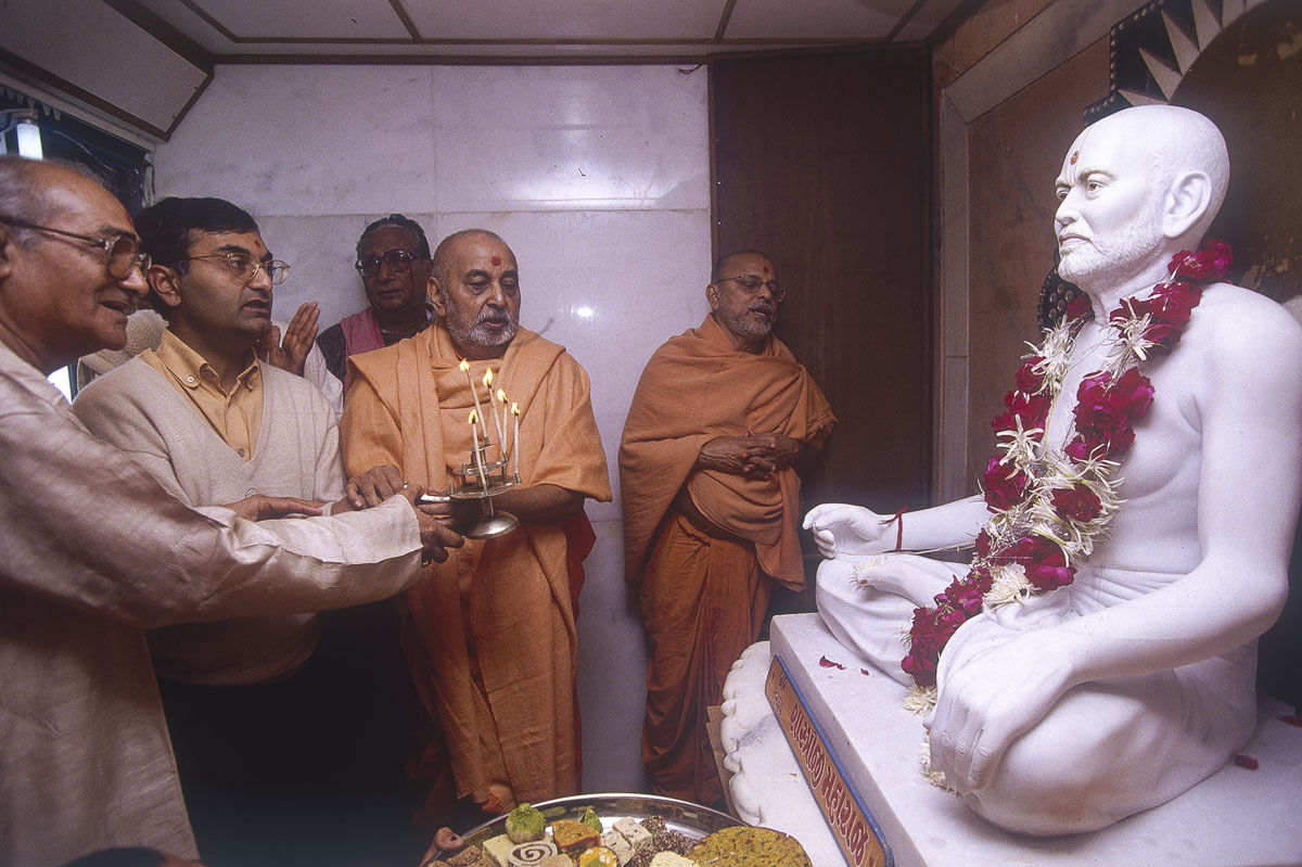 Swamishri and devotees perform the arti