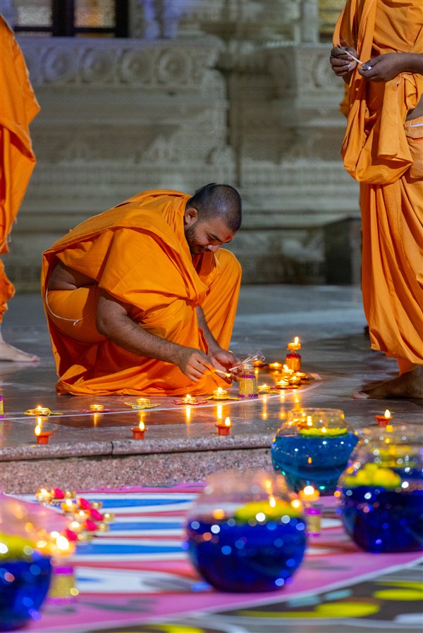 A swami lights Diwali diyas