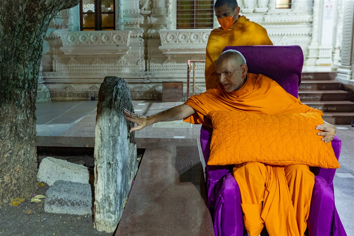 Param Pujya Mahant Swami Maharaj reverentially touches a sacred stone sanctified by Gunatitanand Swami Maharaj