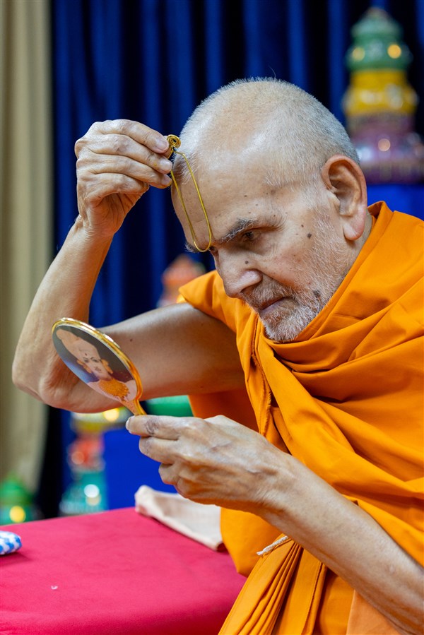 Swamishri applies a tilak on his forehead