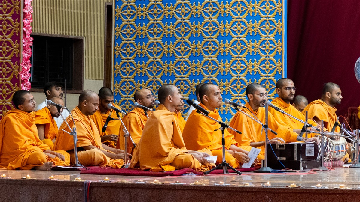 Swamis sing kirtans in Swamishri's daily puja
