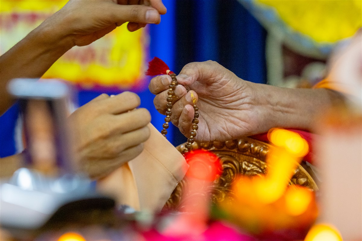 Swamishri prepares to turn the mala in his daily puja