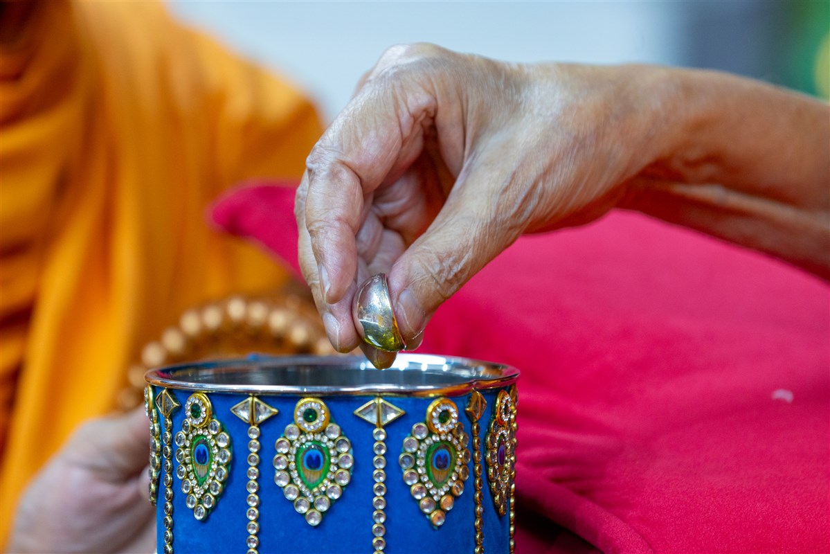 Swamishri sanctifies water with the holy relics of Bhagwan Swaminarayan and the Guru Parampara