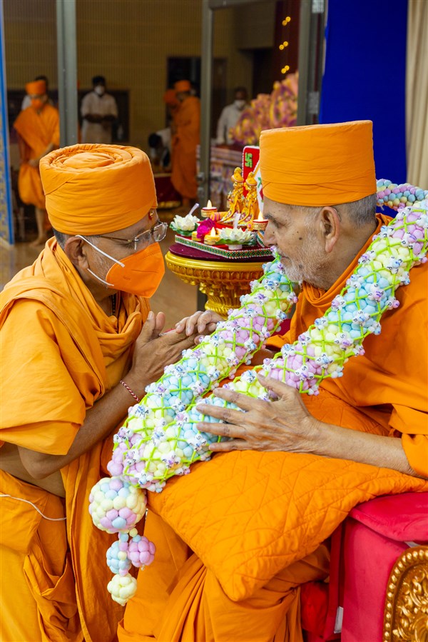 Divyapurush Swami honors Swamishri with a garland