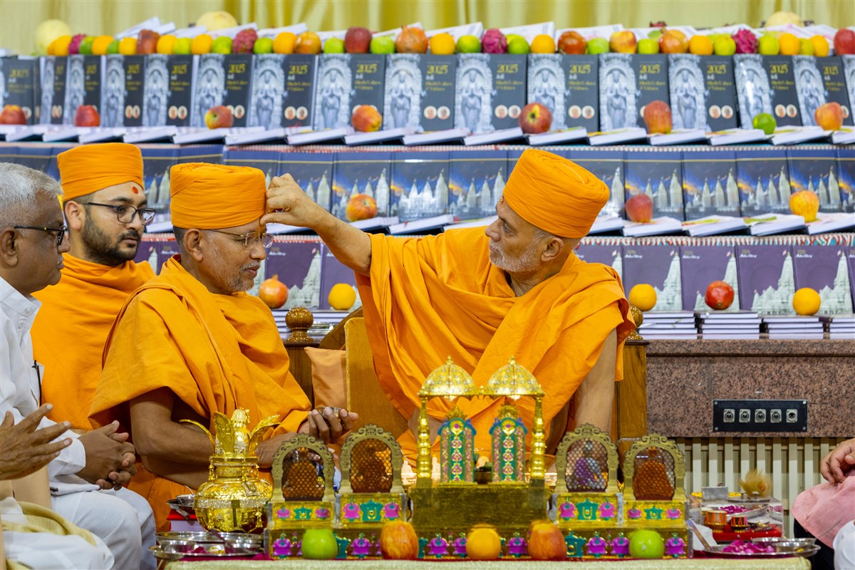 Pujya Viveksagar Swami applies a chandlo to Dipvyapurush Swami 