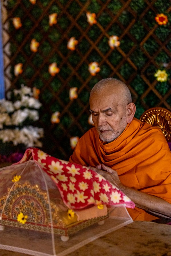 Param Pujya Mahant Swami Maharaj engrossed in darshan of Shri Harikrishna Maharaj and Shri Gunatitanand Swami Maharaj