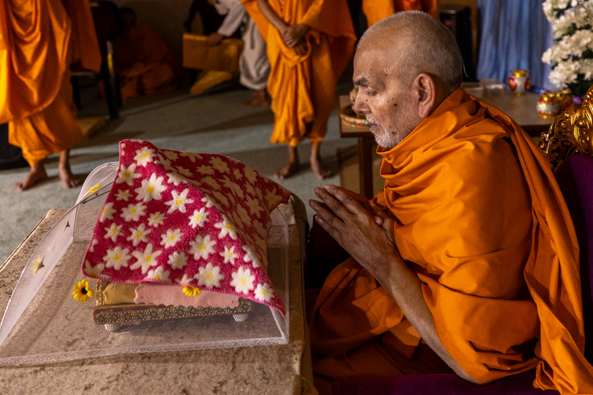 Swamishri engrossed in darshan of Shri Harikrishna Maharaj and Shri Gunatitanand Swami Maharaj