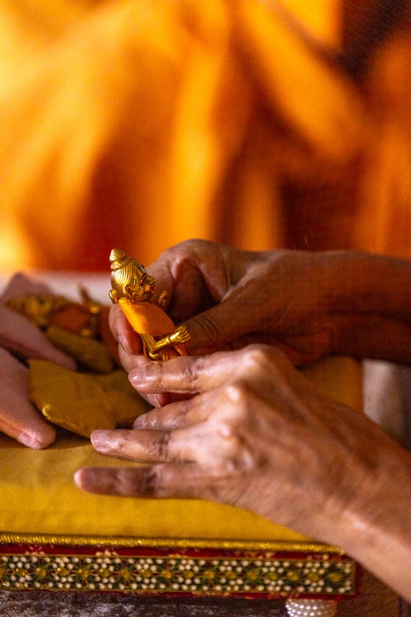 Swamishri engrossed in seva of Shri Harikrishna Maharaj