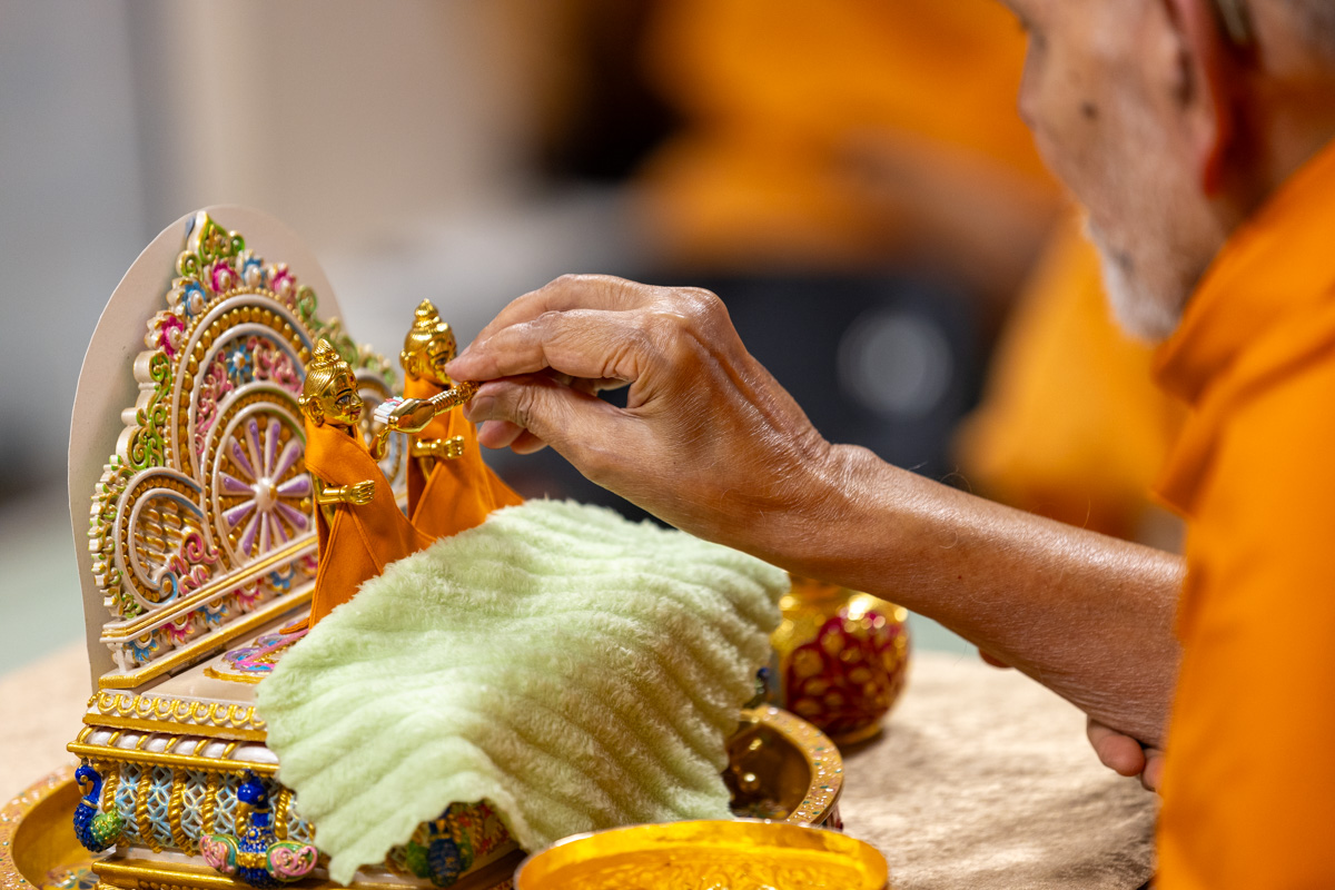 Swamishri performs morning worship rituals of Shri Harikrishna Maharaj... Brush