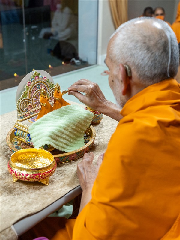 Swamishri performs morning worship rituals of Shri Gunatitanand Swami Maharaj... Brush