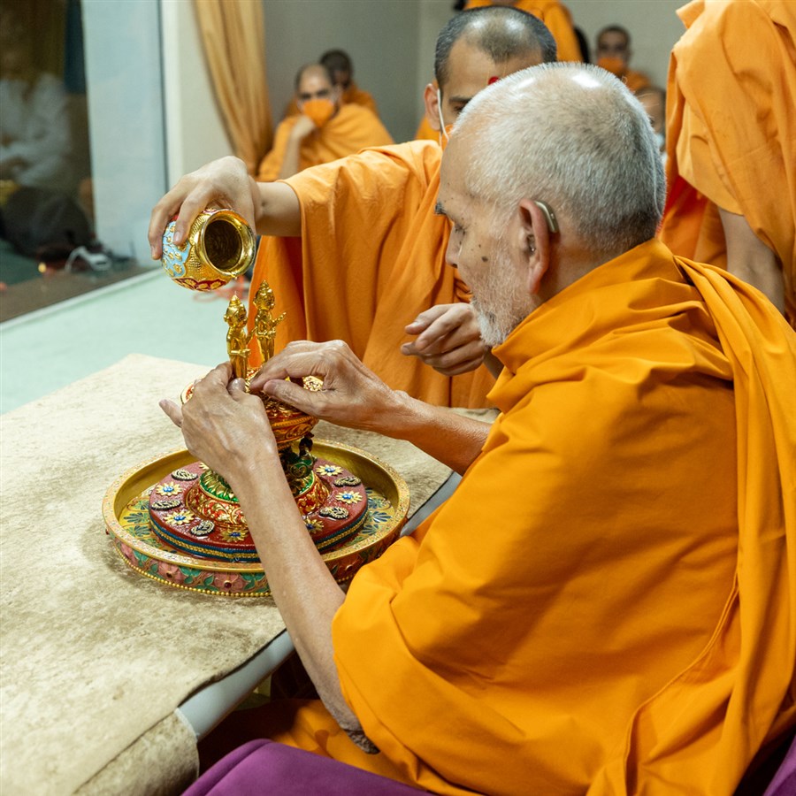 Swamishri bathes Shri Harikrishna Maharaj