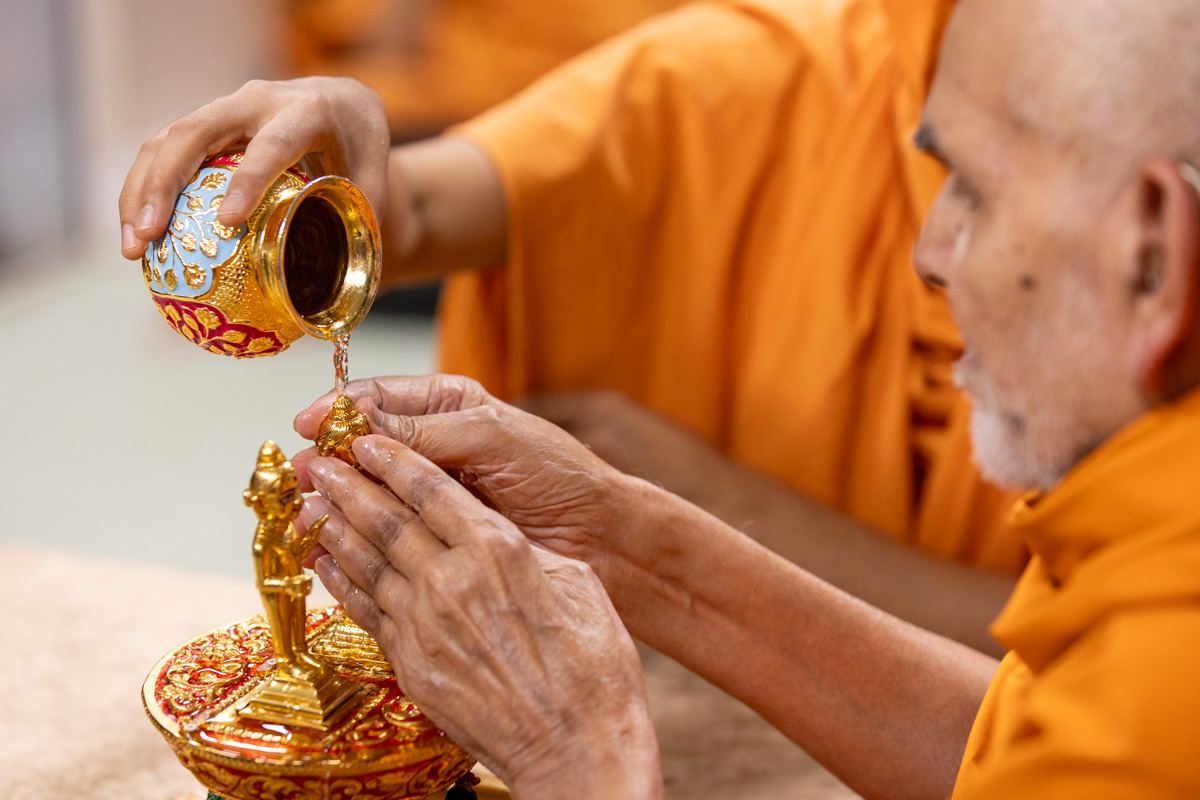 Swamishri bathes Shri Gunatitanand Swami Maharaj