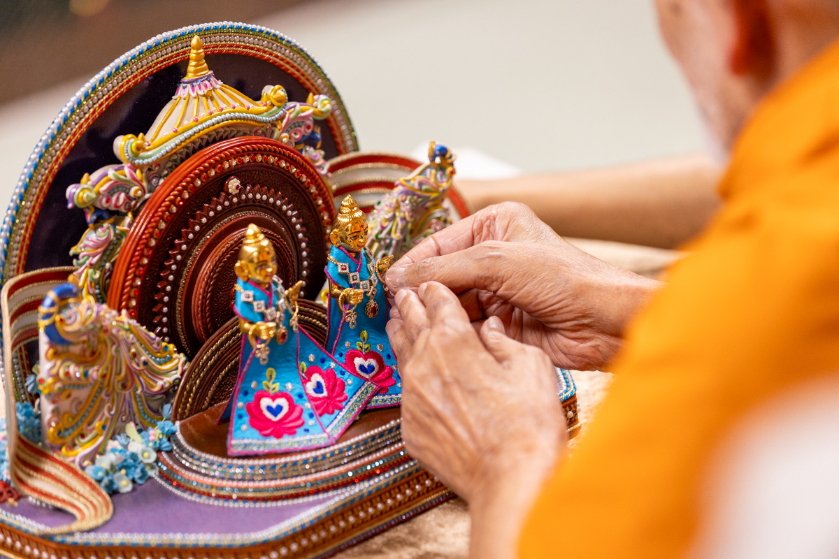 Swamishri adorns Shri Gunatitanand Swami Maharaj with ornaments