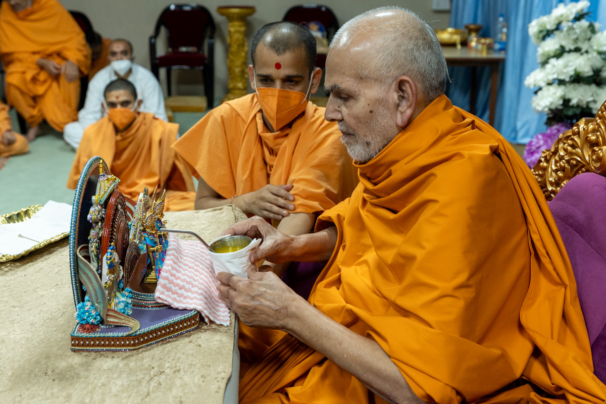 Swamishri offers a drink to Shri Harikrishna Maharaj