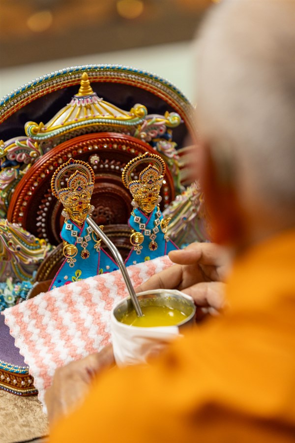 Swamishri offers a drink to Shri Harikrishna Maharaj