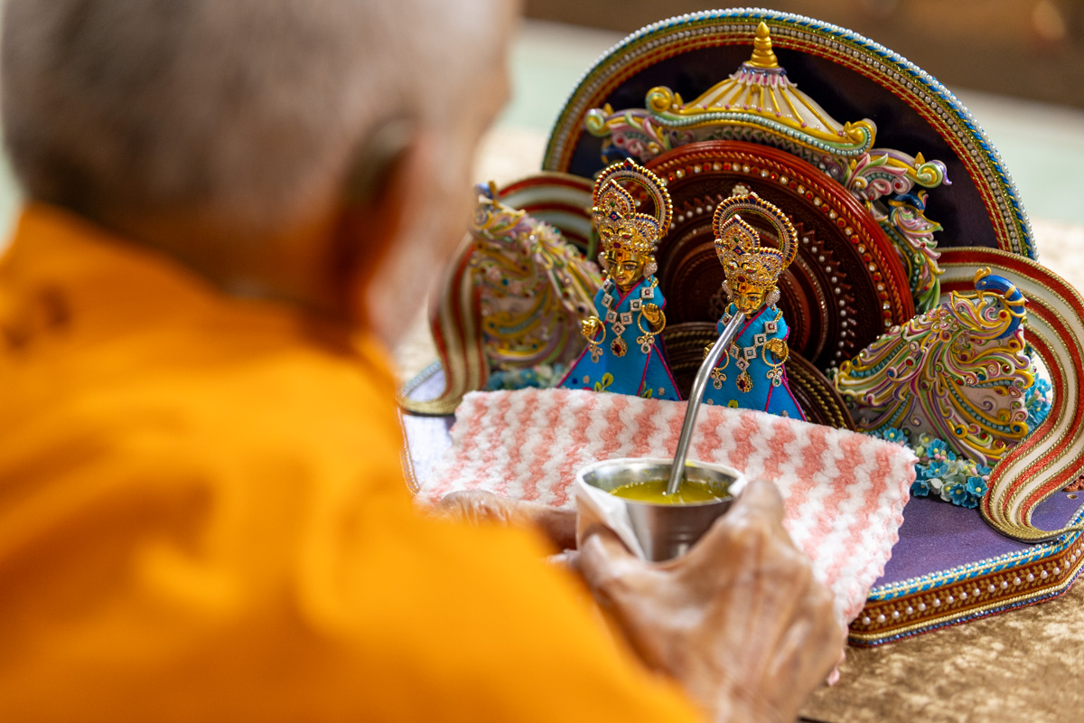 Swamishri offers a drink to Shri Gunatitanand Swami Maharaj