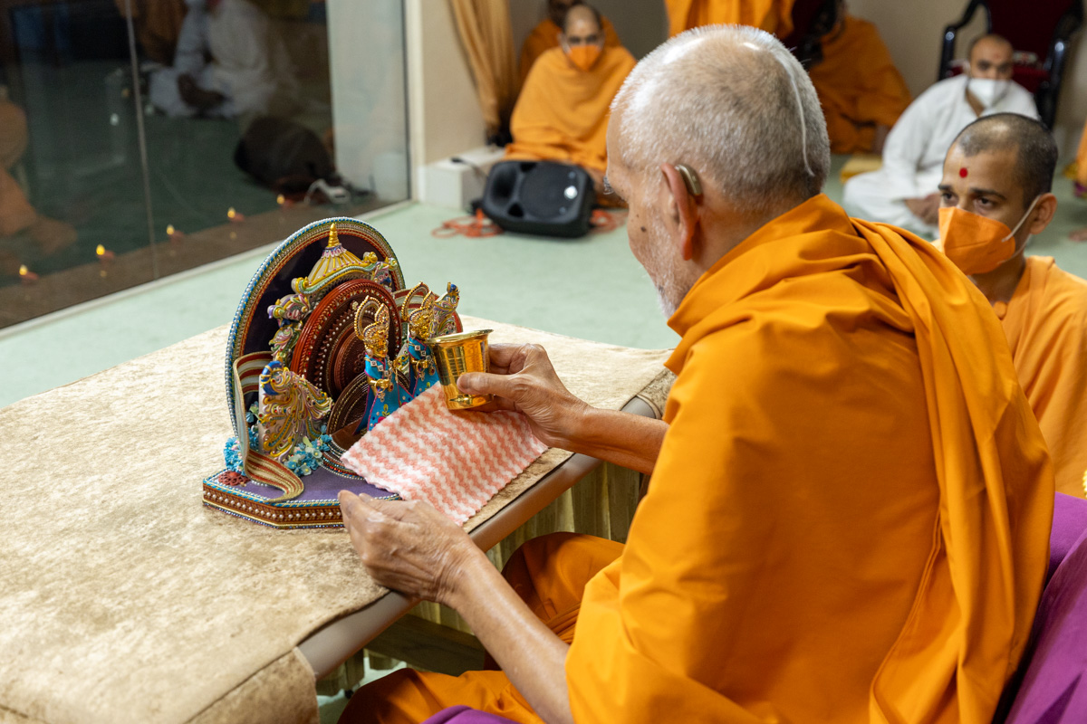Swamishri offers water to Shri Gunatitanand Swami Maharaj