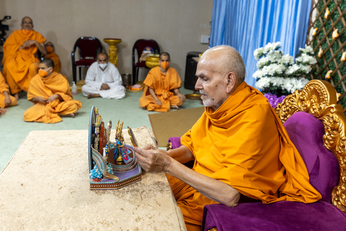 Swamishri offers a mirror to Shri Harikrishna Maharaj