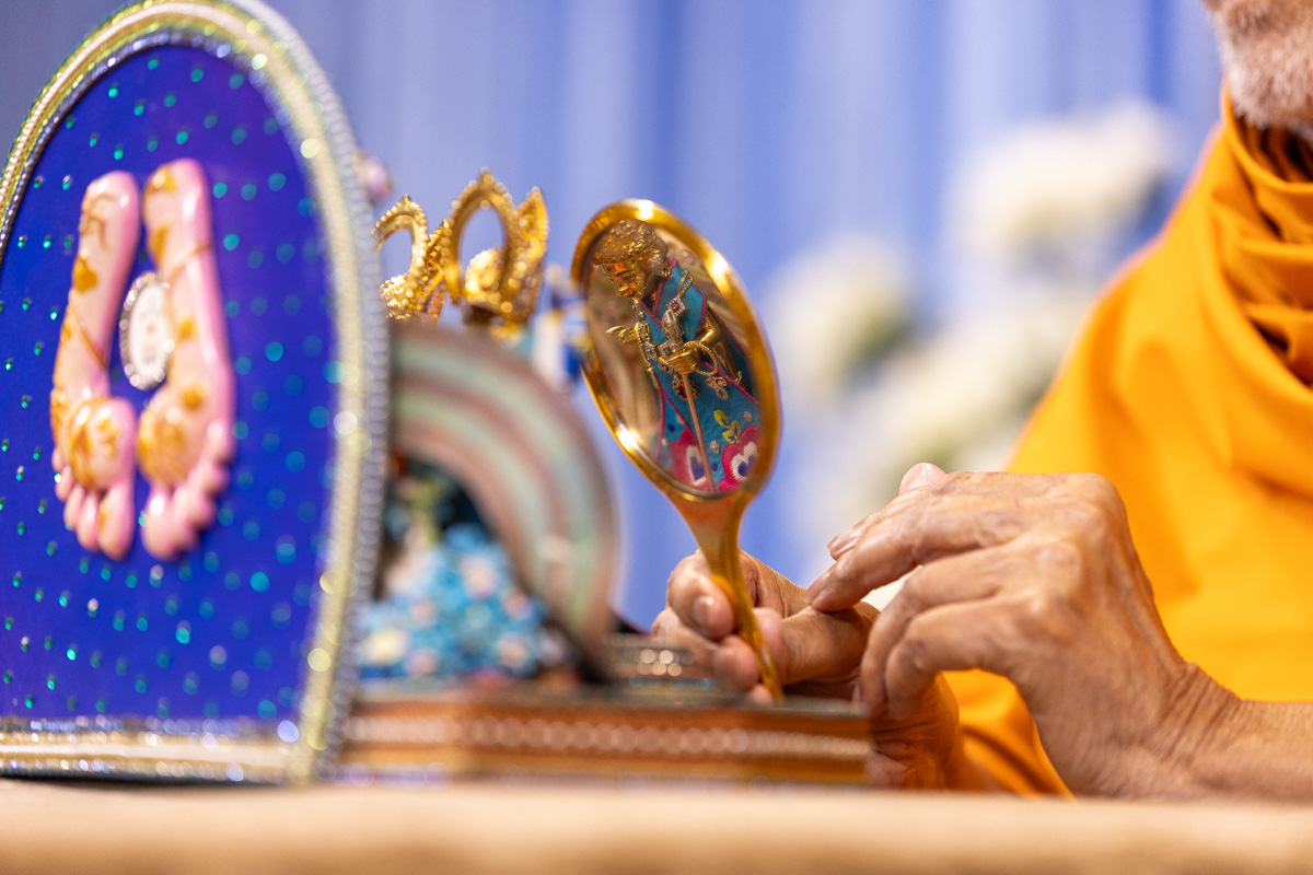 Swamishri offers a mirror to Shri Harikrishna Maharaj
