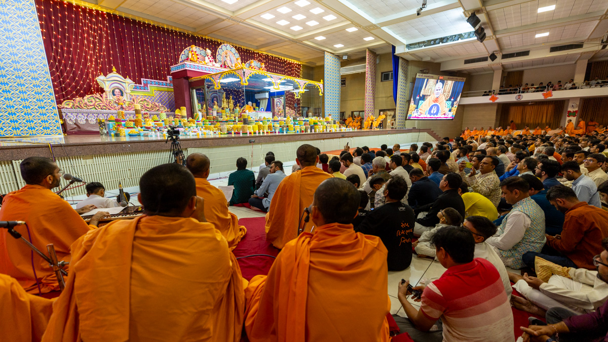 Swamis sing kirtans in Swamishri's daily puja