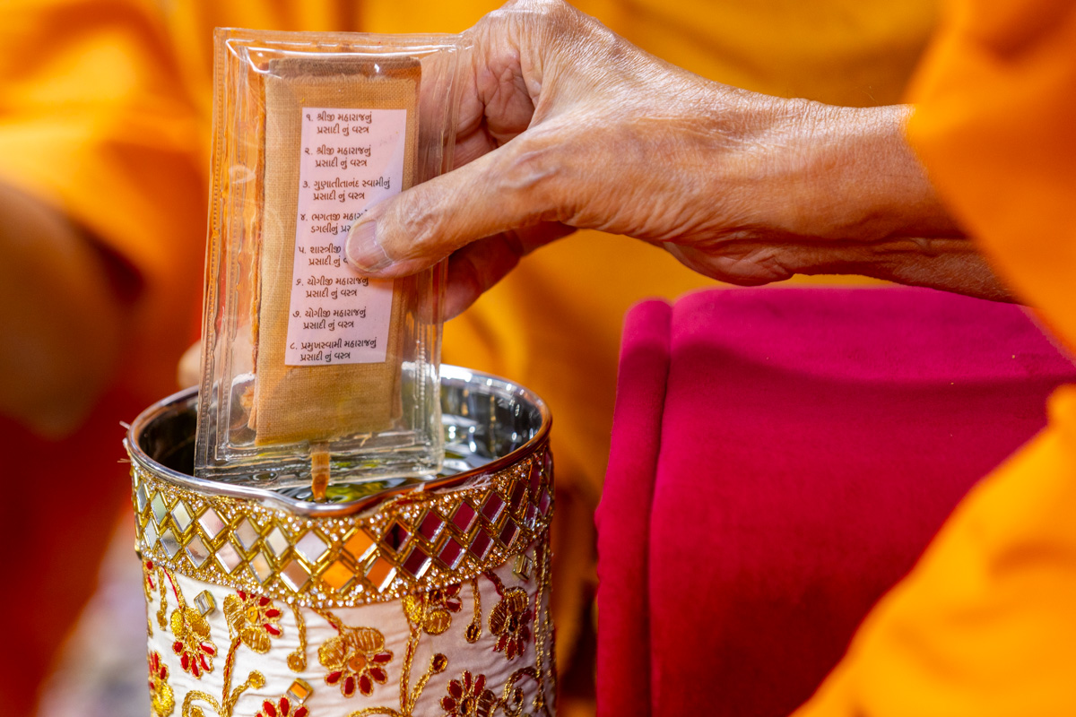Swamishri sanctifies water with the holy relics of Bhagwan Swaminarayan and the Guru Parampara