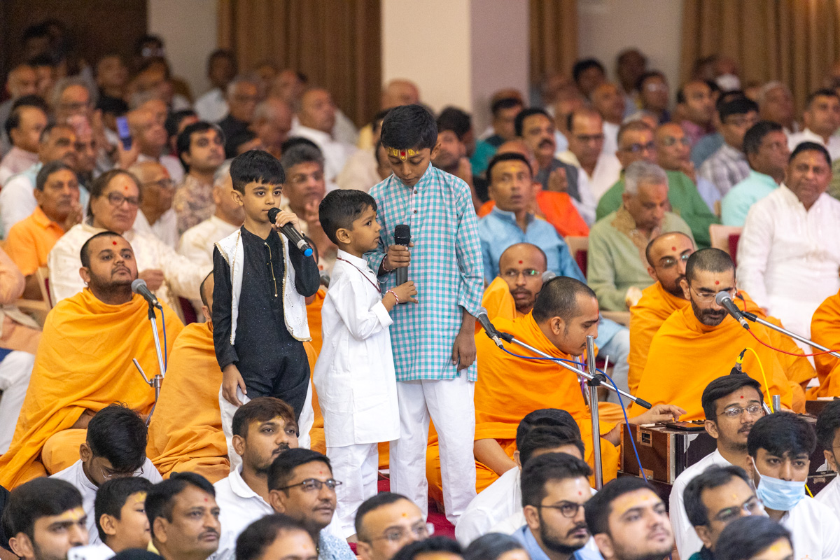 Children lead everyone in reciting the sadhana mantra and daily prayer in Swamishri's puja