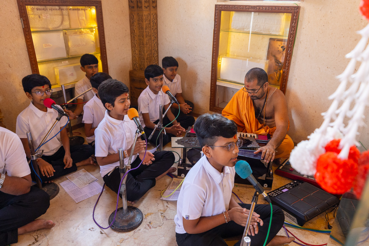 Students of Swaminarayan Vidyamandir, Gondal, sing thals to offer the annakut to Thakorji