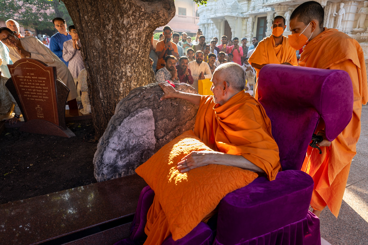 Swamishri reverently touches a sacred stone sanctified by Aksharbrahma Gunatitanand Swami Maharaj