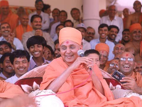 Swamishri in a joyous mood after arriving to the Rajkot mandir from Mumbai at 3:35 pm. Swamishri blesses a throng of 400 devotees who had been avidly waiting for Swamishri's darshan for several hours. 23 Oct 99