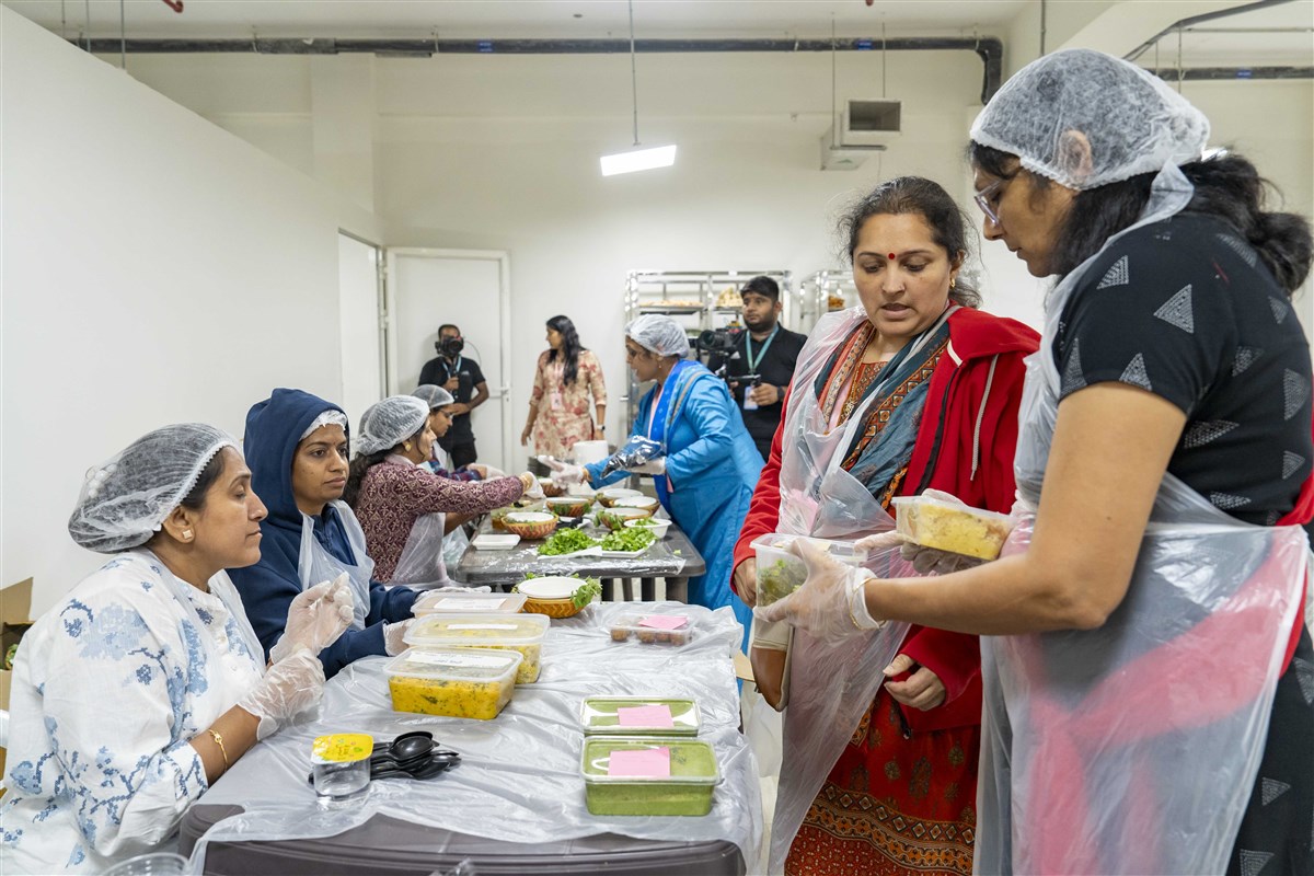 Volunteers organise the freshly cooked sattvic food items to be offered to the deities on the day of Annakut