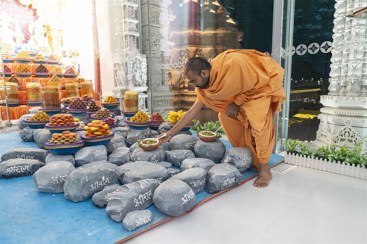 Swami Paramsankalpdas arranges the sacred food over the thematic Ram-Setu