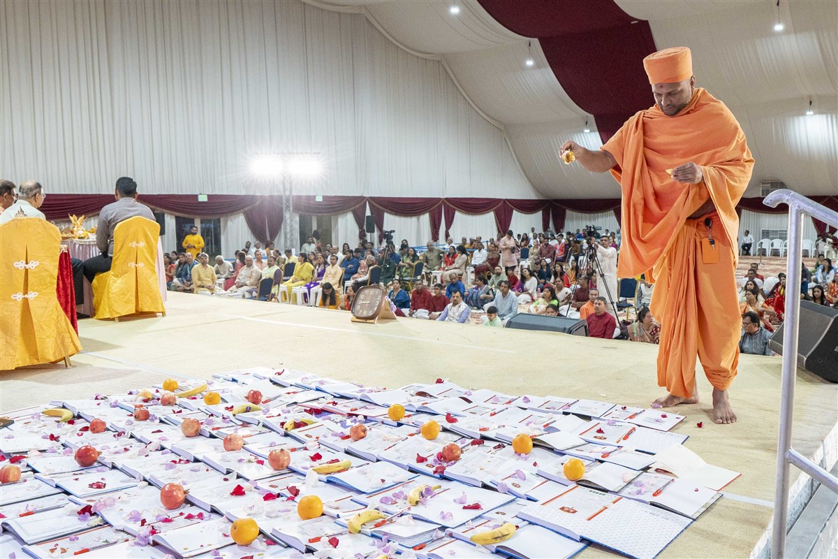 Swami Bahushrutdas showers sanctified flower petals on the books of devotees