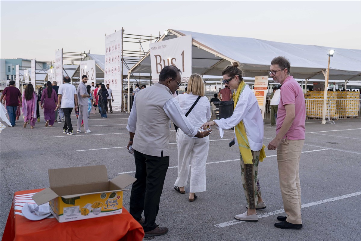 Volunteers selflessly serve the visitors with water
