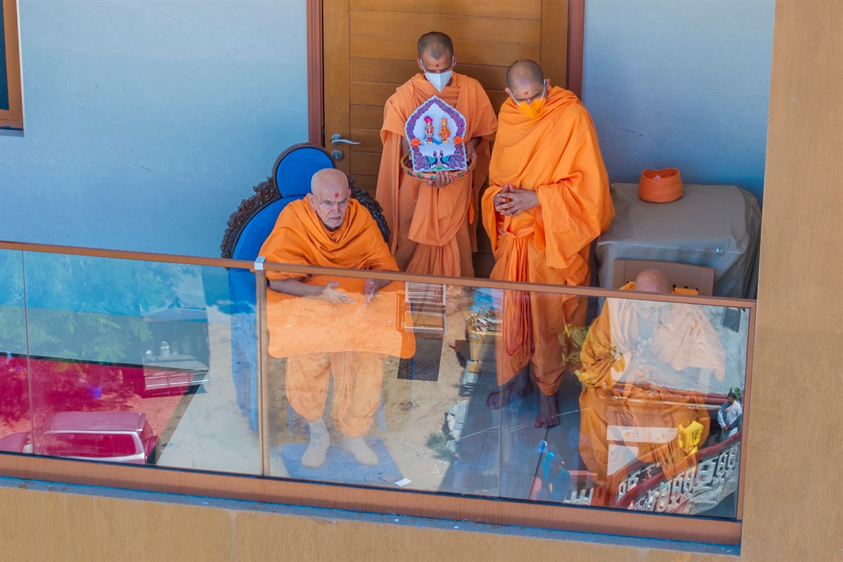 Swamishri observes the nagar yatra from the mandir gallery