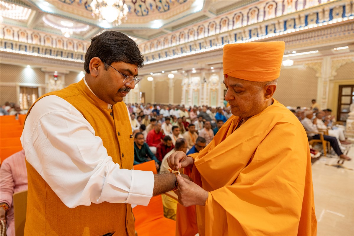 Brahmavihari Swami ties a nadachhadi to an invited guest