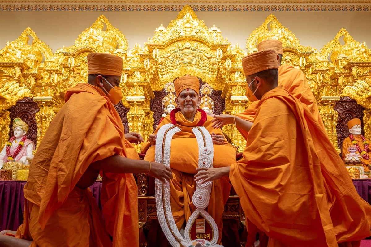 Swamis honor Swamishri with a garland