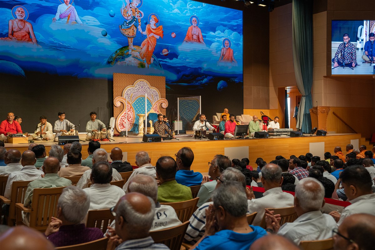 Devotees sing kirtans at the beginning of the murti-pratishtha assembly in the evening