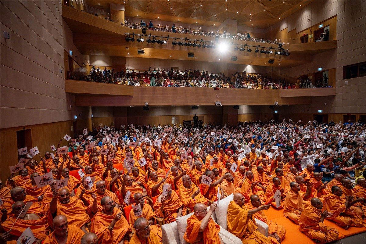 Senior swamis, swamis and devotees wave flags