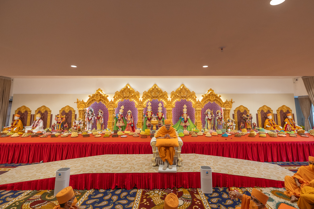 Swamishri greets all with folded hands. For more photos, please click <a href='https://www.baps.org/Photos/2025/Murti-Pratishtha-32612.aspx?mid=276605' target='blank' style='text-decoration:underline; color:blue;'>here</a>