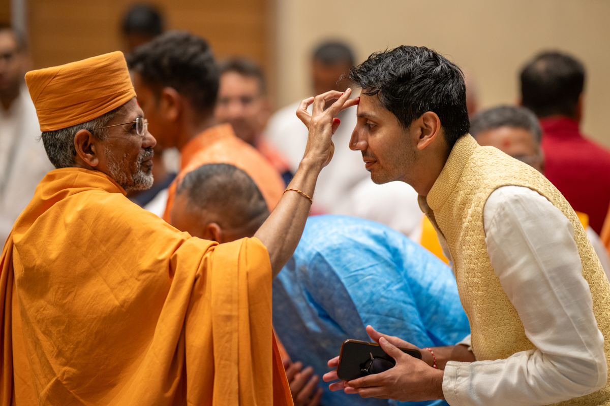 Atmatrupt Swami applies a chandlo to a devotee