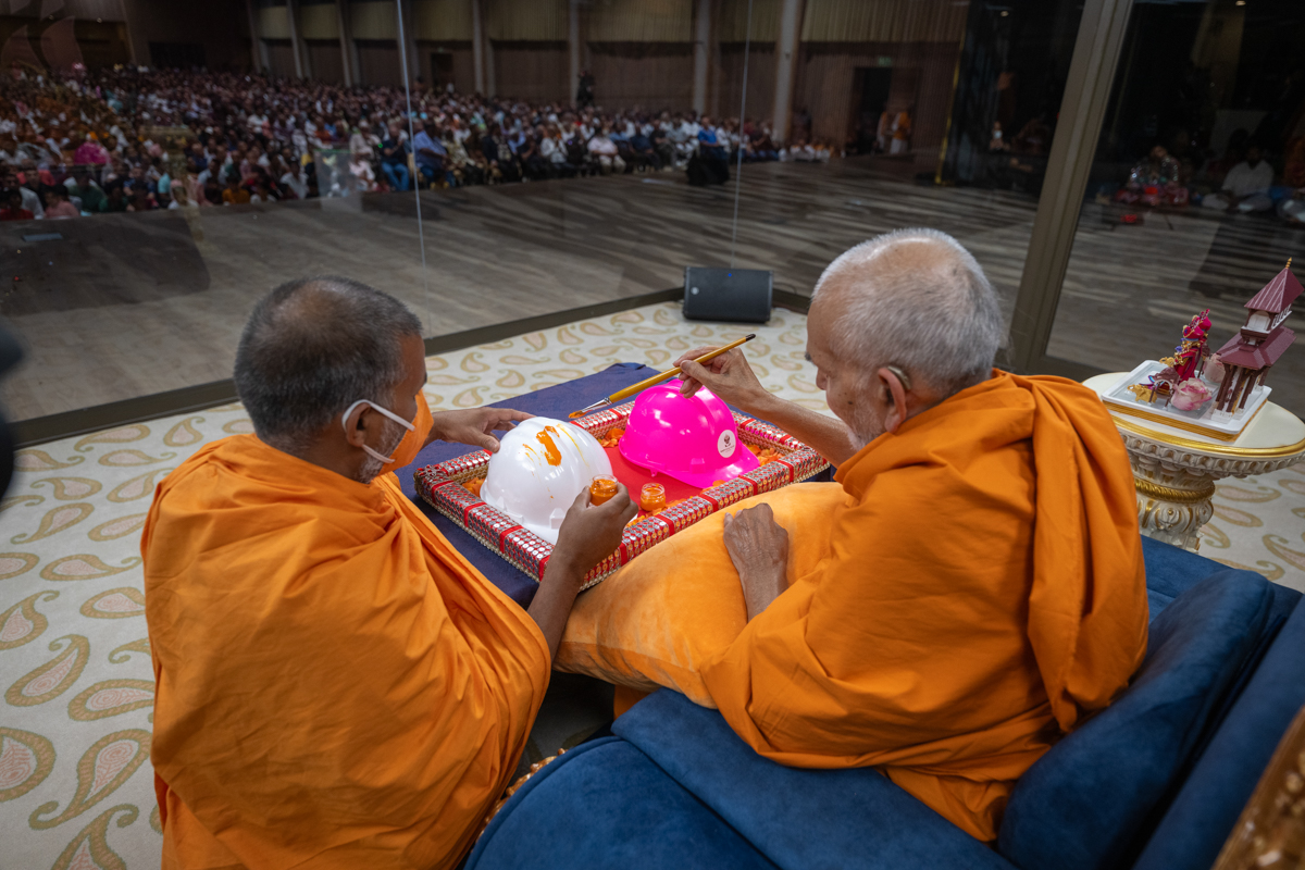 Swamishri paints on a helmet