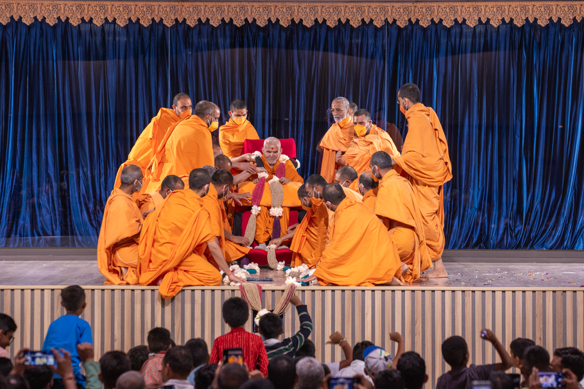 Swamis honor Swamishri with a garland