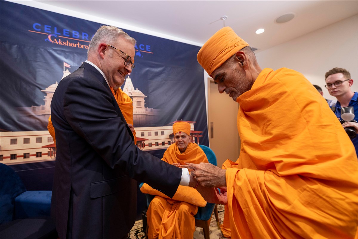 Pujya Anandswarup Swami tying a nadachadi on the wrist of Prime Minister, Hon Anthony Albanese