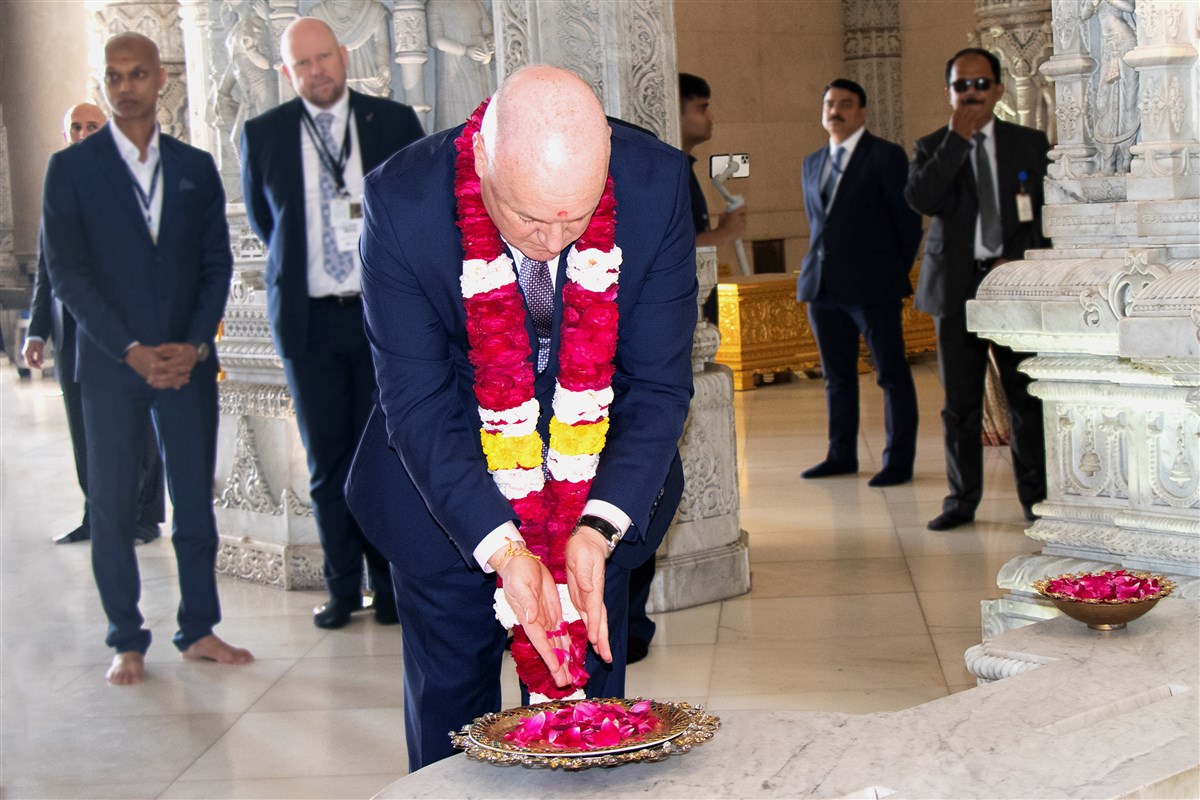 Prime Minister Luxon respectfully offers flower petals to the murti of Bhagwan Swaminarayan