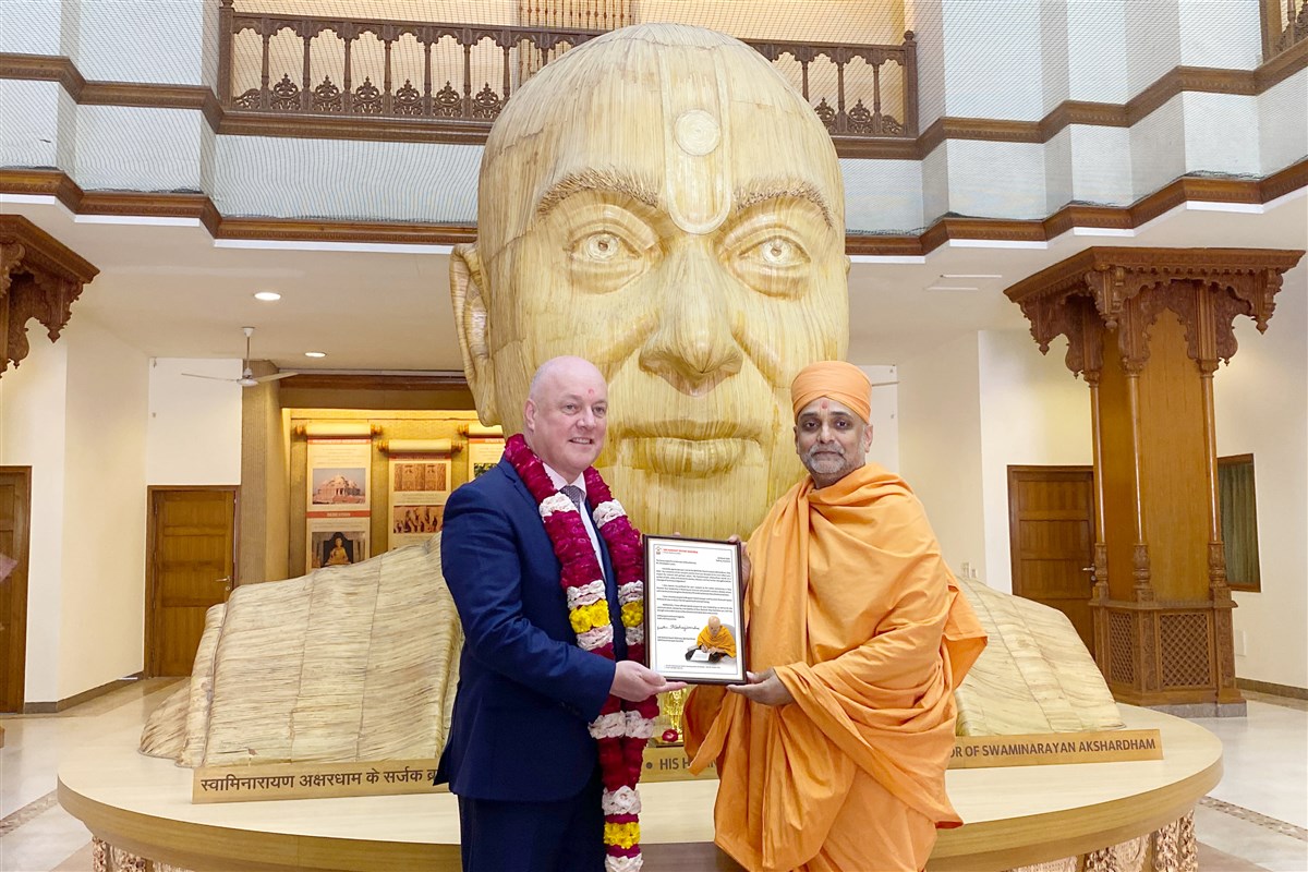 Gnanmuni Swami presents a letter from HH Mahant Swami Maharaj to New Zealand Prime Minister Christopher Luxon