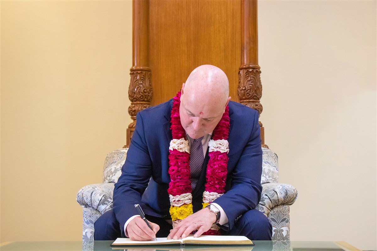 New Zealand Prime Minister Christopher Luxon pens his sentiments in the guest book