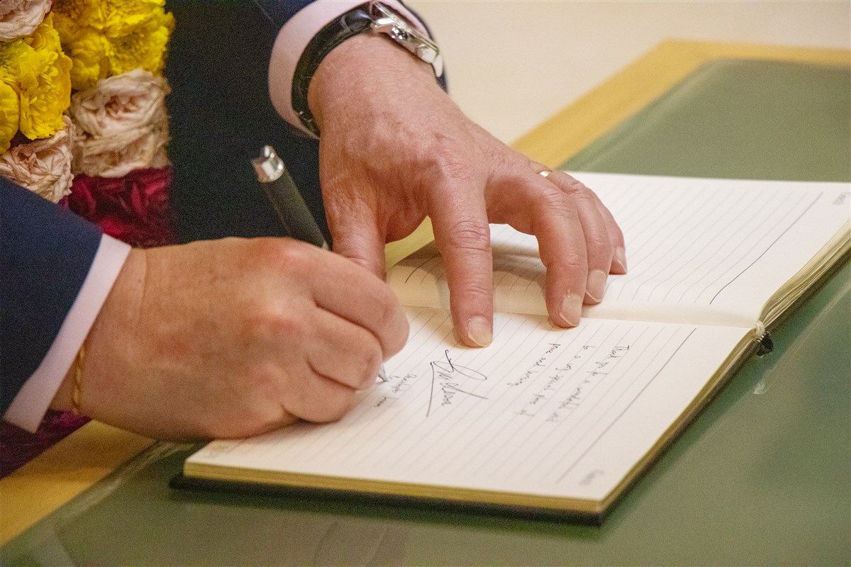 New Zealand Prime Minister Christopher Luxon pens his sentiments in the guest book